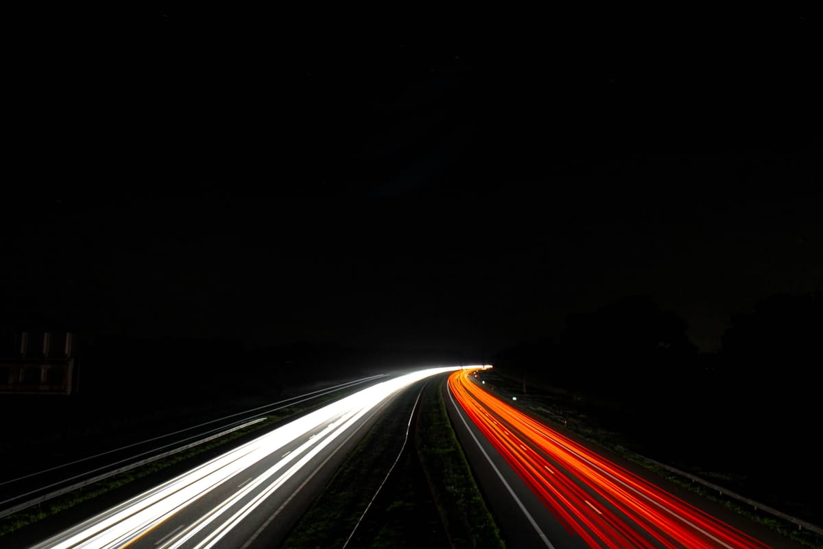 Lichtsporen van auto’s op een snelweg in de nacht